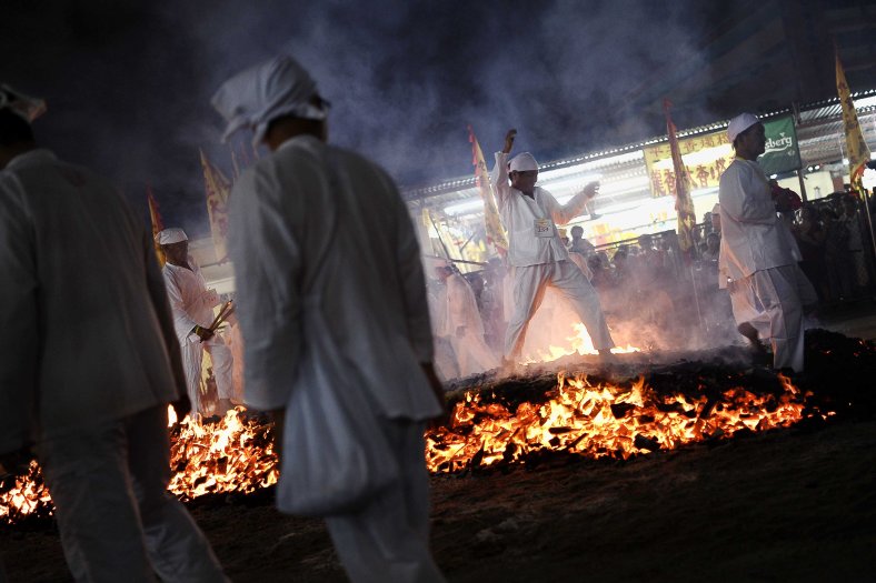 Malaysian Chinese devotees walk barefoot over burning coals during the last day of Nine Emperor Gods Festival at Nine Emperor Gods temple outside Kuala Lumpur on October 02, 2014. The nine-day Taoist festival, believers welcome the “emperor gods” who they believe live amongst the stars, in order to bring good fortune, longevity and good health. Some devotees stay at a temple during the festival, which begins on the eve of the ninth lunar month of the Chinese calendar, where they consume vegetarian meals and recite continuous prayers. Photo Adib Rawi Yahya