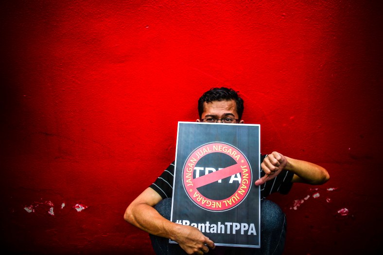 A man holds a placard in protest against the controversial Trans-Pacific Partnership Agreement (TPPA) as U.S. President Barack Obama attends the 27th Association of South-East Asian Nations (ASEAN) Summit in Kuala Lumpur on November 21, 2015. The U.S. President delivered Malaysia needs to decide whether it will join Trans-Pacific Partnership (TPP) by mid of January next year. photo Adib Rawi Yahya